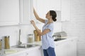 Woman opening the kitchen cupboard stock photo