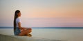 Calm young woman in tank top and denim shorts sits on the pier at sunset Royalty Free Stock Photo