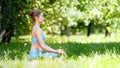 Calm young woman in tracksuit practices relaxing yoga pose lotus sitting on meadow grass Royalty Free Stock Photo