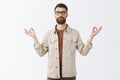 Calming down with yoga. Portrait of relieved peaceful good-looking urban guy in jacket with long sick beard closing eyes