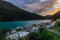 Calming view on camping trailers by the fjord shore against mountains and dramatic clouded sky