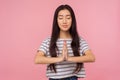 Calmness, harmony and yoga practice. Portrait of peaceful girl with long brunette hair in striped t-shirt holding arms in namaste