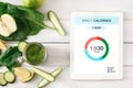 Daily calories counting app opened on digital tablet next to healthy greens Royalty Free Stock Photo