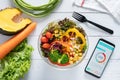 Calories counting , diet , food control and weight loss concept. Calorie counter application on smartphone screen at dining table Royalty Free Stock Photo