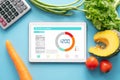 Calories counting , diet , food control and weight loss concept. tablet with Calorie counter application on screen at dining table Royalty Free Stock Photo