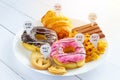 Calories counting and food control concept. doughnut ,croissant ,chocolate and cookies with label of quantity of calories