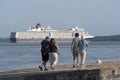 Calshot Hampshire UK, A passing cruise ship and people walking on the beach Royalty Free Stock Photo