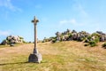 Calvary in front of a granite outcrop under a bright sunshine in Brittany, France