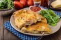 Calzone pizza stuffed with cheese and prosciutto