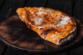 Calzone - Stuffed Pizza with Tomato, Mozzarella and Ham on wood