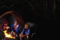 Camaraderie around the campfire. three young boys sitting by the campfire. Royalty Free Stock Photo