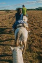 People riding horses in a rural landscape