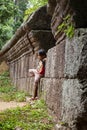 Little girl standing against an old stone wall