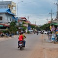 Boy in a red T-shirt rides a scooter through the city, Asian slums