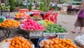 Elderly Asian woman chooses fruit in the bazaar