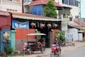 little Asian girl plays in a motor rickshaw, a scooter rides along the road