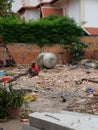 Man in a red shirt sitting on a pile of construction waste