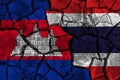 Cambodia VS Thailand flag painting on cracked background . Confliction and crisis concept .