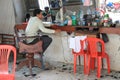 Cambodian barber waiting for clients