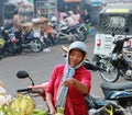 Cambodian female street vendor of banana and fruits covered the head with a loincloth and standing beside the street in the fresh