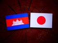 Cambodian flag with Japanese flag on a tree stump isolated