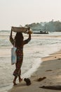 Cambodian girl carrying a basket with goods on a beach of the Koh Rong Island in Cambodia