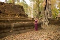 Cambodian Asian Girl in Traditional Dress by Ancient Temple Ruins in Angkor Thom