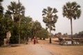 Happy Smiling Cambodian Asian Girl in Traditional Dress by Palm Trees at Angkor Wat Temple Royalty Free Stock Photo