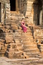 Cambodian Girl in Khmer Dress Sitting at Bayon Temple in Angkor City Royalty Free Stock Photo