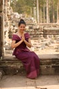 Cambodian Girl in Khmer Dress Sitting in the Terrace of the Elephants in Angkor City