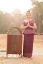 Happy Smiling Cambodian Asian Girl in Traditional Dress Standing by a Trash Can Royalty Free Stock Photo