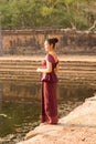 Asian Girl in Traditional Dress Sits by a Pool of Water in Angko