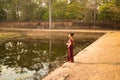 Happy Cambodian Asian Girl in Traditional Dress Stands by a Pool of Water in Angkor Thom near Temple Royalty Free Stock Photo