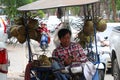 Cambodian man of coconut juice street vendor sitting on his three wheels motorcycle of his Kiosk that can move to various places