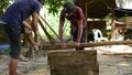 Cambodian man prepares wood to build home construction by traditional way using handsaw