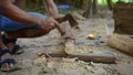 Cambodian man using axe to incise wooden beam