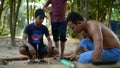 Cambodian man using axe to incise wooden beam