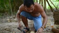 Cambodian man using axe to incise wooden beam