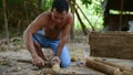 Cambodian man using axe to incise wooden beam