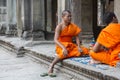 Cambodian monks sitting on stairs at Angkor Wat temple, Cambodia