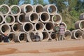 Cambodian street construction site with workers and concrete pipes