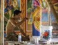 Cambodian young artist paints a temple near Kampot.