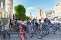 Many people seat in shade near gothic King`s College Porters` Lodge, many bikes Royalty Free Stock Photo