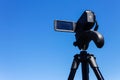 Camcorder on a tripod against a clear blue sky