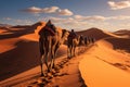 Camel caravan in the desert at sunset. Travel Concept. Background with a copy space. Royalty Free Stock Photo