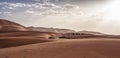 Camel caravan with people going through the sand dunes in the Sahara Desert. Morocco, Africa Royalty Free Stock Photo