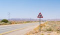 Camel crossing road sign on a way through the desert Royalty Free Stock Photo