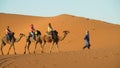 Camel driver with tourist camel caravan