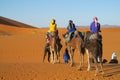 Camel driver with tourist camel caravan in desert Royalty Free Stock Photo