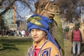 Camel driver wearing traditional national clothes leads a camel along a city street during a holiday.